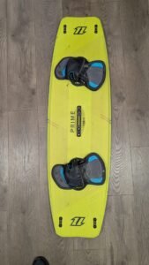Bright yellow wakeboard with blue-and-gray bindings on a wooden floor.