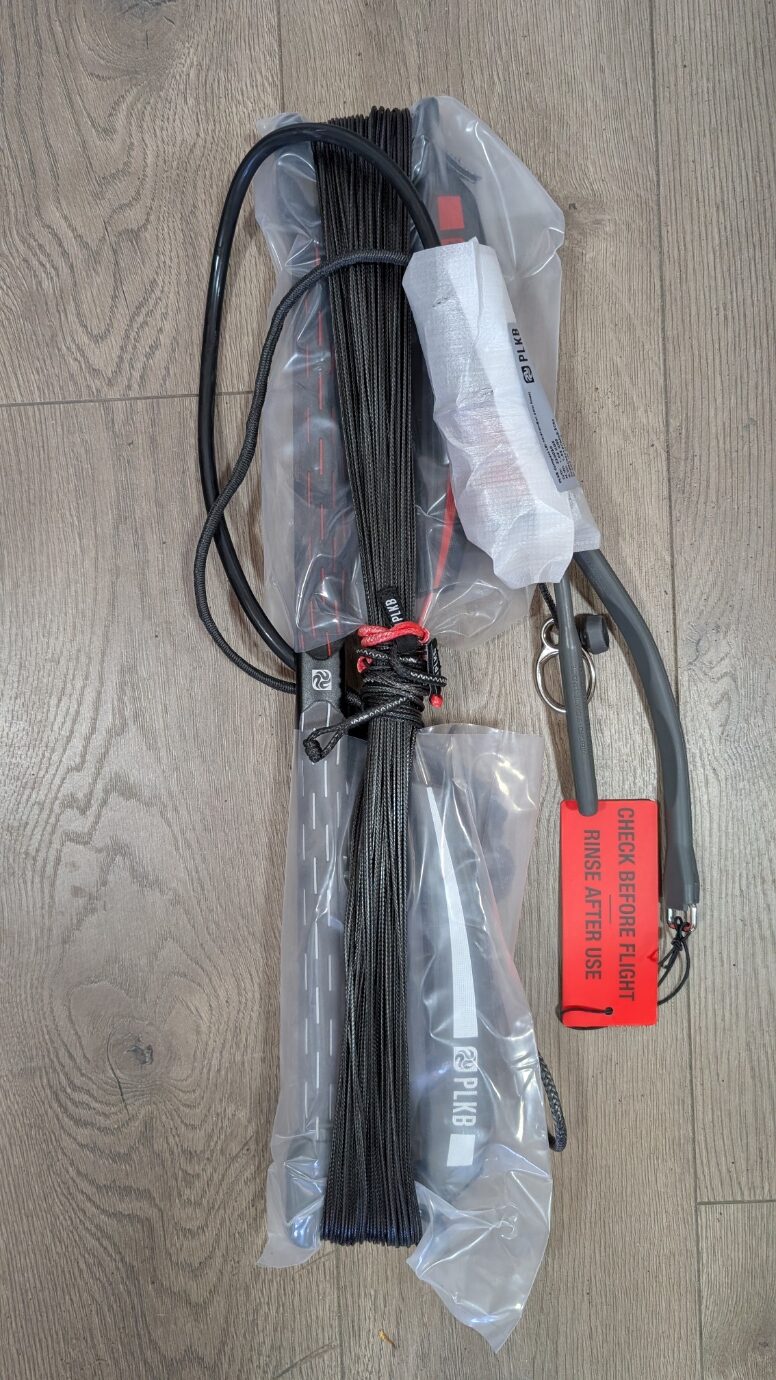 Bundle of black woven straps with red thread ties, stored in plastic bag, labeled with a bright orange “Check Before Flight” tag.